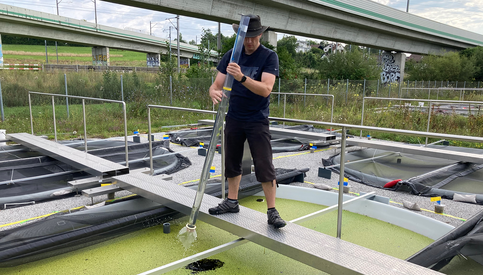 Martin Schäfer nimmt eine Wasserprobe aus einem der Versuchsteiche (Foto: Christoph Walcher, Eawag). Martin Schäfer nimmt eine Wasserprobe aus einem der Versuchsteiche (Foto: Christoph Walcher, Eawag).